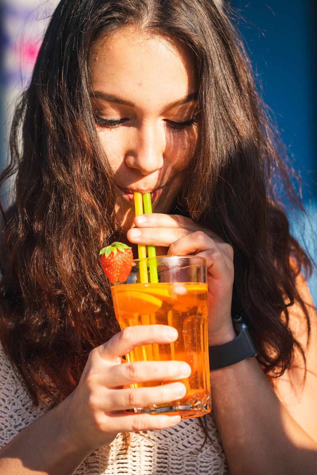Frau trinkt einen Drink in der Sonne