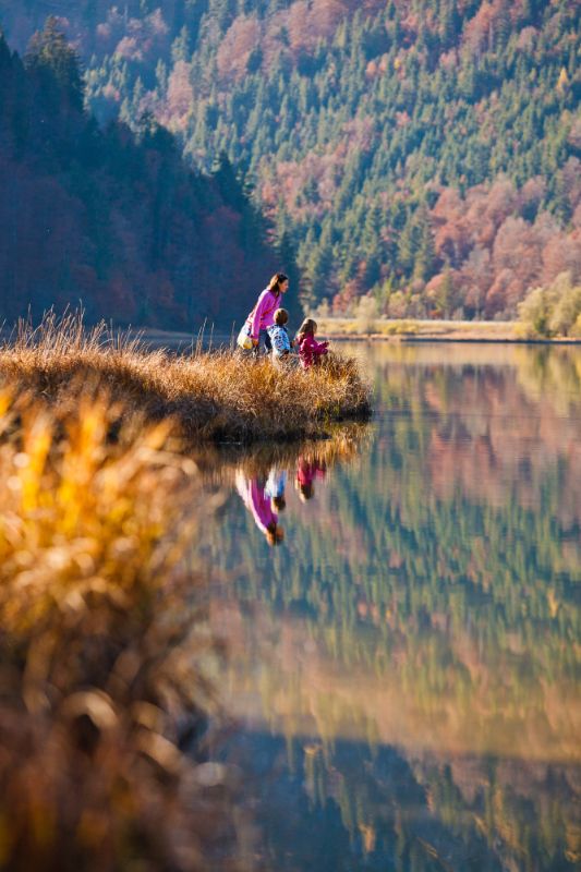 Familie am See spiegelt sich im Wasser