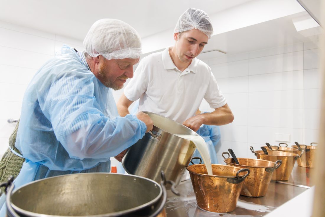 Die Kaser füllen die erwärmte Milch um