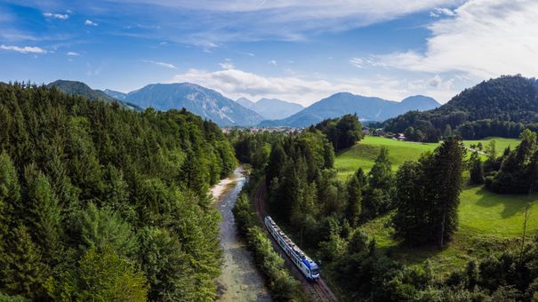 Ein Zug der BRB fährt durch den Wald von Ruhpolding nach Traunstein.