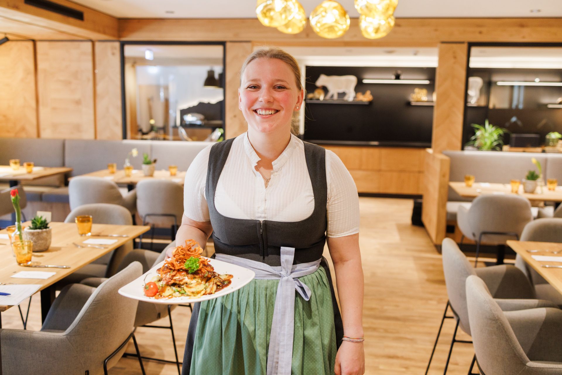 Eine Mitarbeiterin serviert ein Gericht