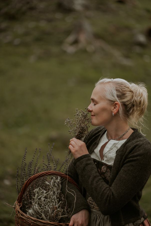 Frau riecht an Blumen.