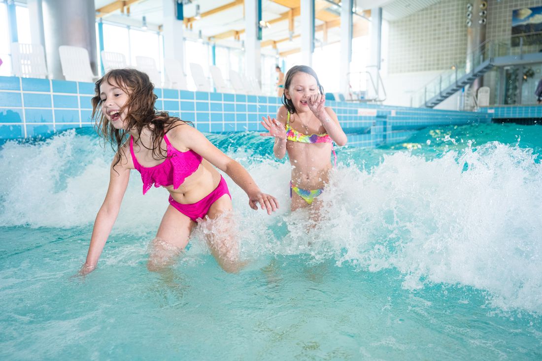 Kinder spielen in der Welle