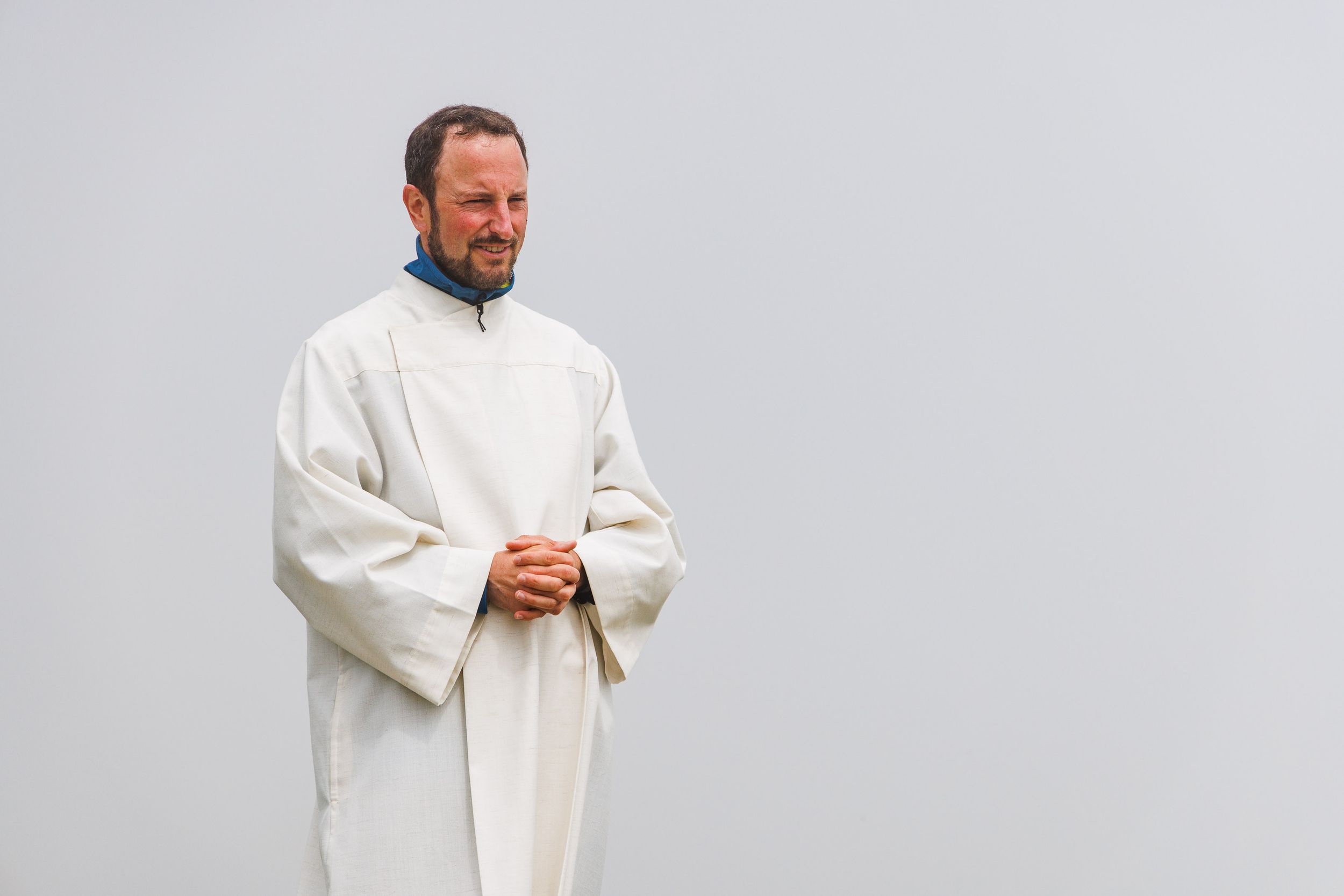 Pastoralreferent Georg Gruber im weißen liturgischen Gewand beim Berggottesdienst vor grauem Himmel