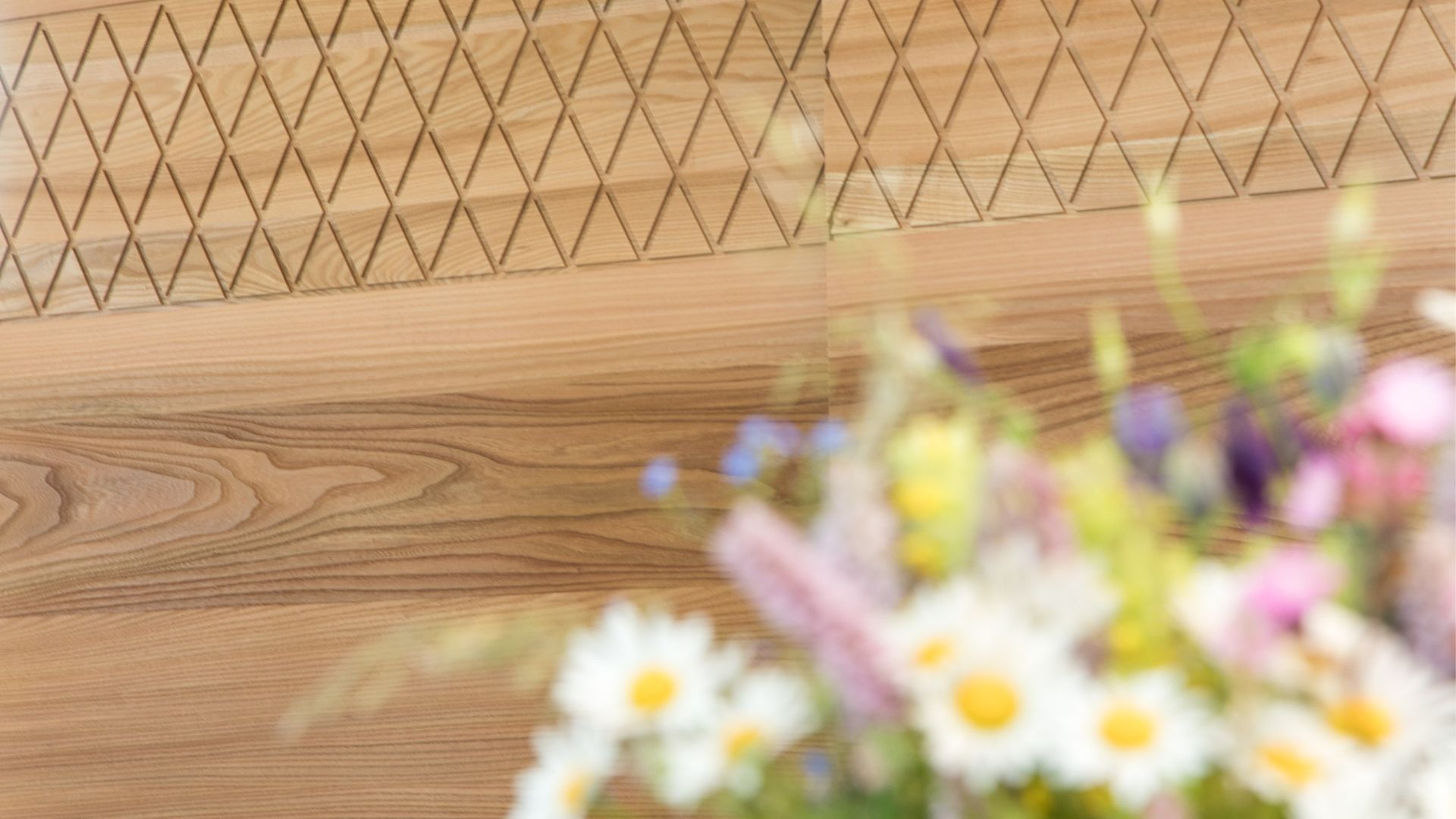 Blumen vor einer Holzwand